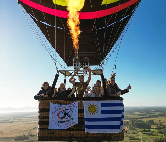 grupo de viajeros de el kaminante volando en globo con la bandera de uruguay