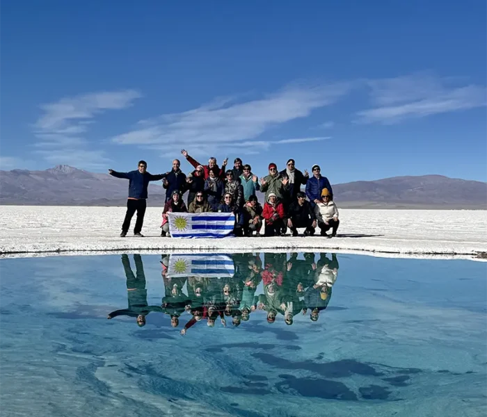 grupo de viajeros de el kaminante posando con la bandera de uruguay