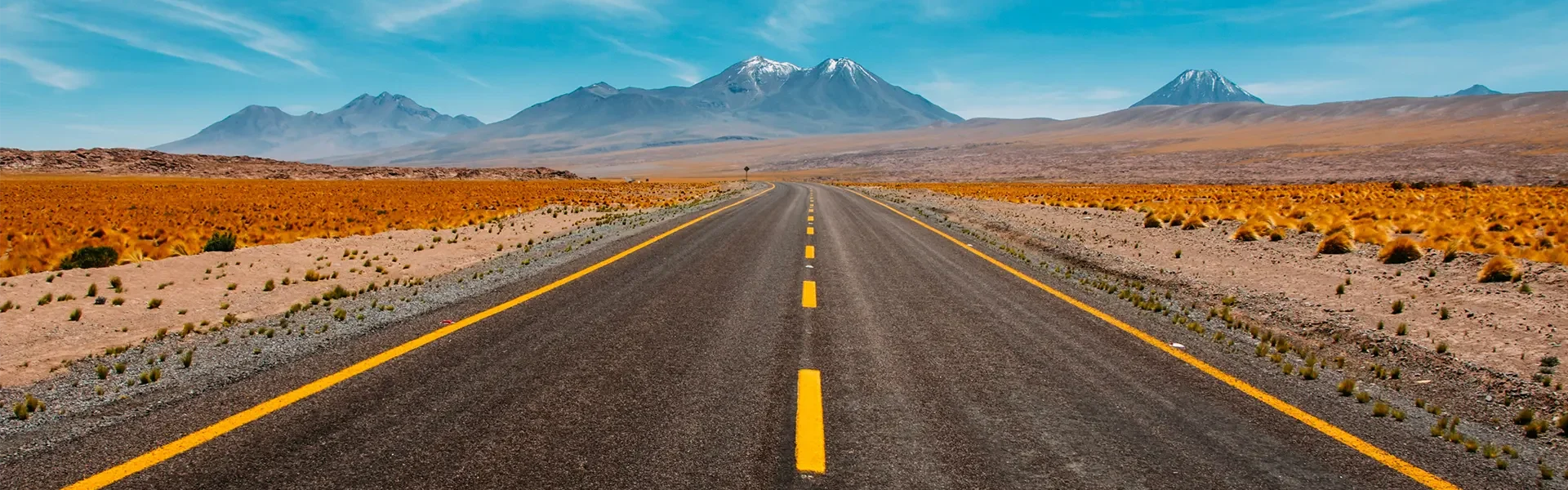 ruta en el desierto con montañas a lo lejos